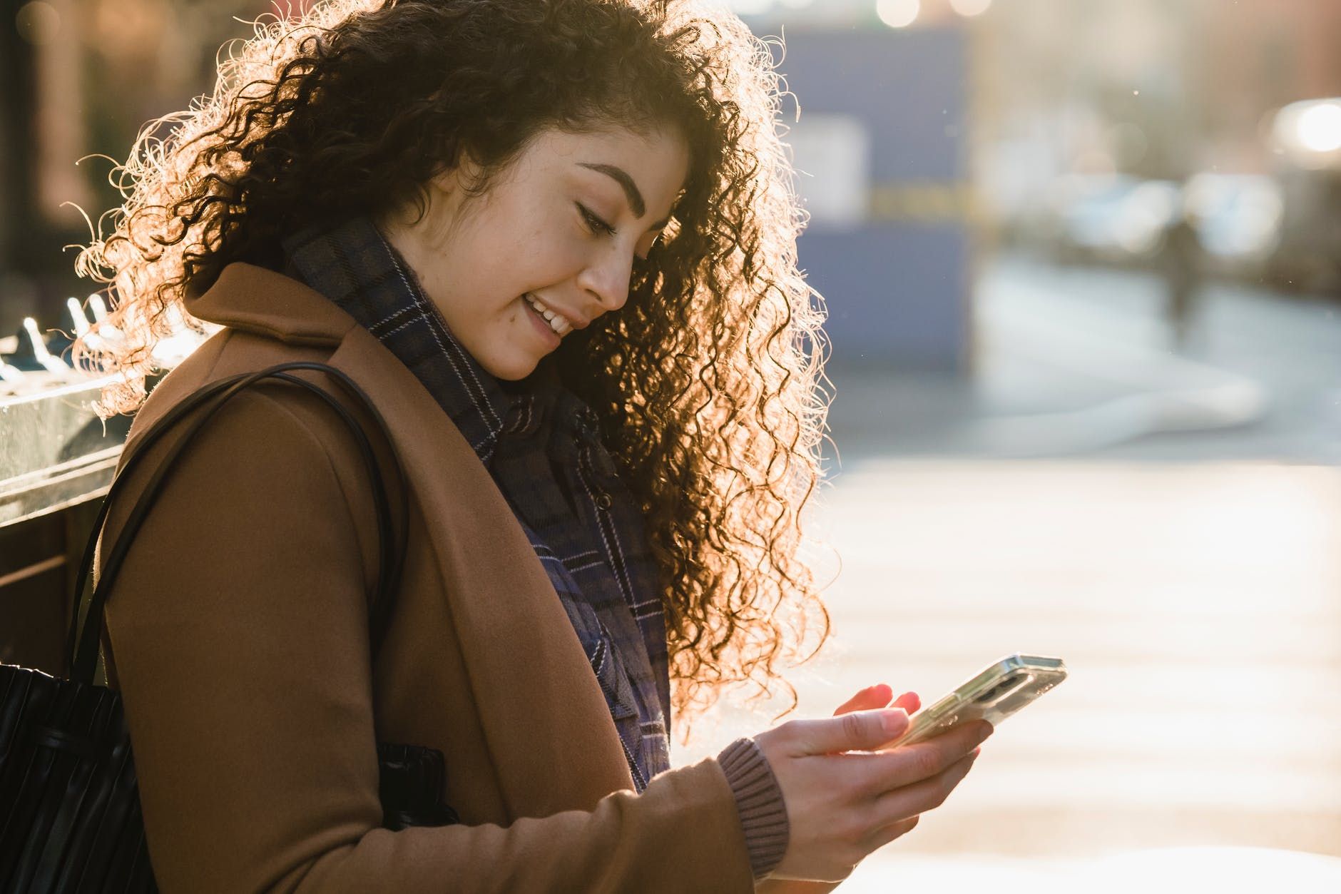 positive woman chatting online on smartphone